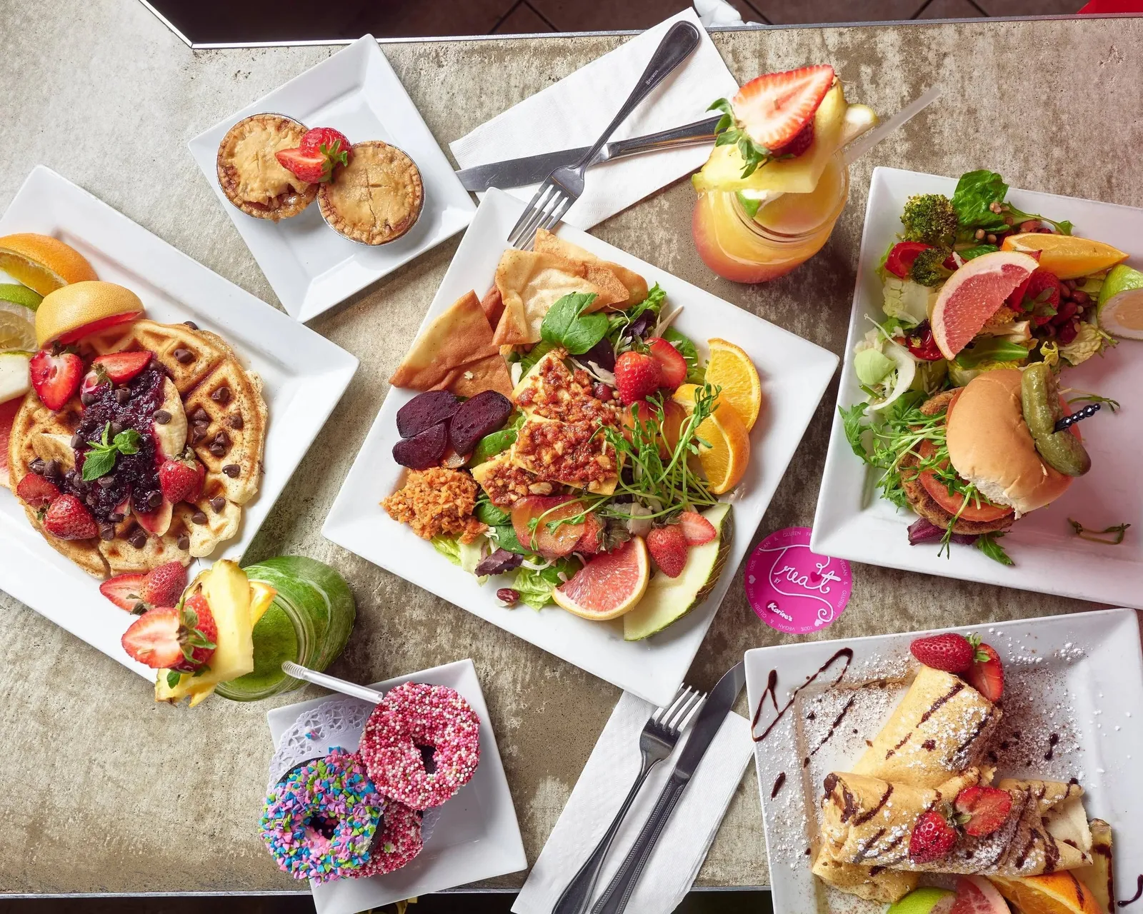 Waffles, a tofu salad plate and a burger with fresh fruit at Karine's